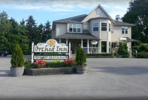 un cartel de posada de mariscos frente a una casa en Orchid Inn, en Niagara on the Lake