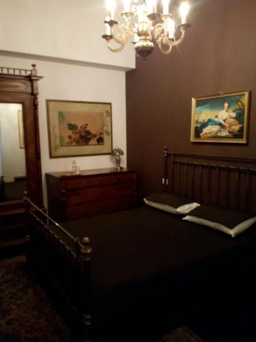a bedroom with a bed and a chandelier at Palace B&B in Acquaviva delle Fonti