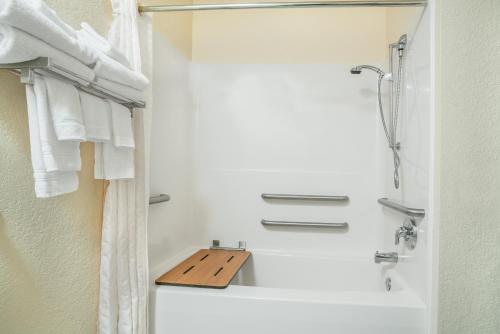 a bathroom with a shower and a sink and towels at Microtel Inn & Suites Tomah in Tomah