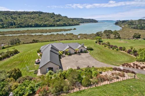 an aerial view of a house on a hill next to a lake at Okura River Estate Getaway in Auckland