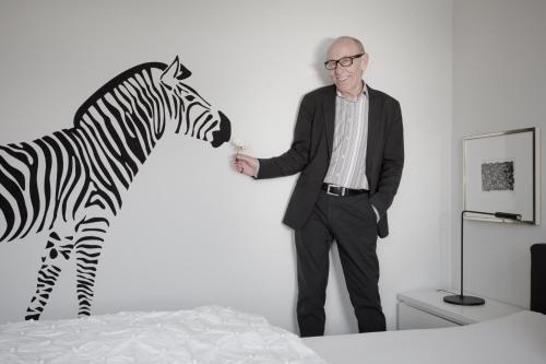 a man standing next to a zebra on a bed at Designhotel Rosenbohm in Oldenburg