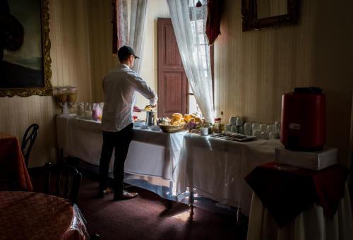 um homem de pé em frente a uma mesa com comida em Hostal Sucre em Sucre