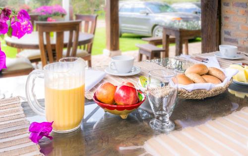 a table with a bowl of fruit and a glass of orange juice at San Mateo Hotel Campestre in Nobsa