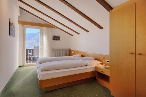sypialnia z dużym łóżkiem i oknem w obiekcie Appartment Maria w mieście Schenna