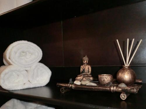 a shelf with a buddha statue and towels on it at Varandas de Alter Hotel & SPA in Alter do Chão