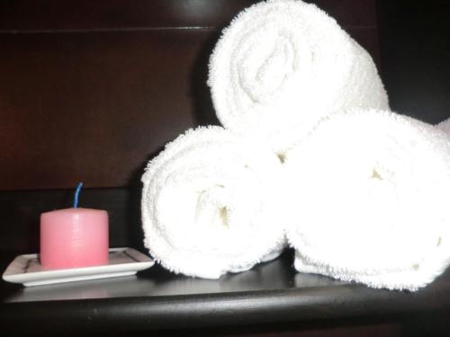 a stack of towels and a candle on a table at Varandas de Alter Hotel & SPA in Alter do Chão