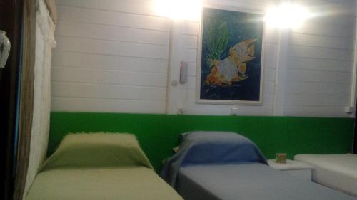 1 Schlafzimmer mit 2 Betten und einer grünen Wand in der Unterkunft Pousada Algas Marinhas in Fernando de Noronha