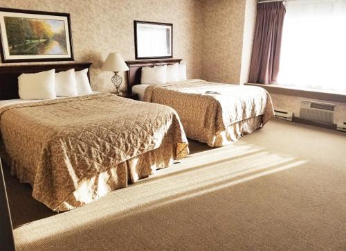 a hotel room with two beds and a window at Alex Hotel and Suites in Anchorage