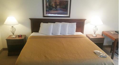 a hotel room with a bed with two tables and two lamps at Alex Hotel and Suites in Anchorage