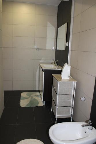 a bathroom with a sink and a toilet and a mirror at A Primeira Casinha do Mé-Mé in Manteigas