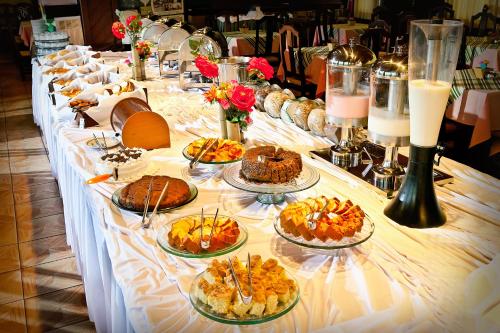 een lange tafel met veel borden eten erop bij Hotel Fazenda Figueiras in Imbé