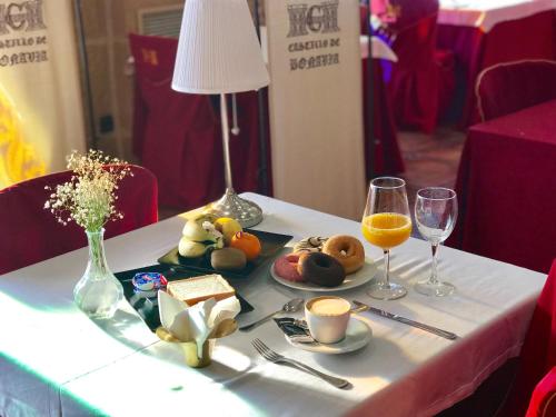 a table with a plate of food and two glasses of orange juice at Hotel Castillo Bonavía in Pedrola