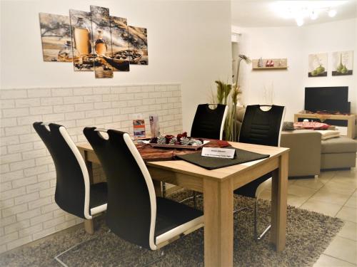 uma mesa de jantar com cadeiras pretas à volta em Sterne-Ferienwohnung-Apartment Regnitztal em Buttenheim
