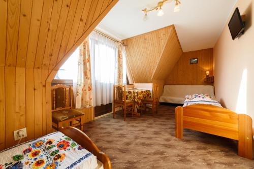 1 dormitorio con 2 camas, mesa y sillas en Czarna Góra - Pokoje, en Czarna Góra