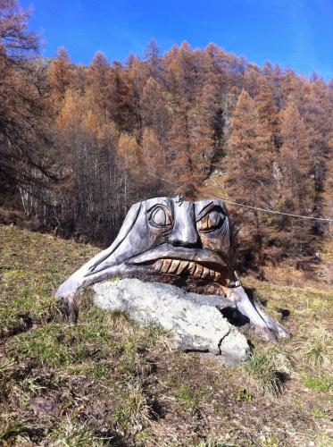 a statue of a head on a rock in a field at Hotel Gran Baita in Gressoney-Saint-Jean