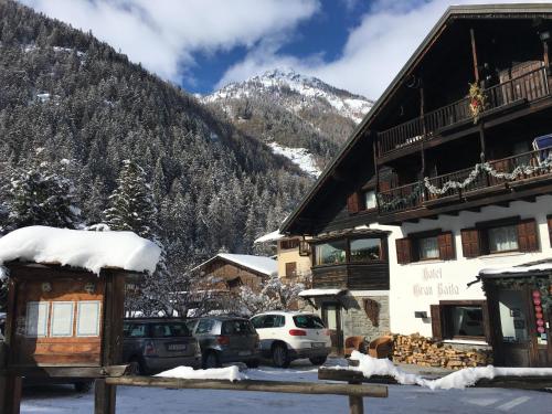 a ski lodge with a snow covered mountain in the background at Hotel Gran Baita in Gressoney-Saint-Jean