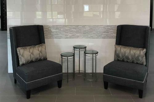 two chairs and two stools in a room at Wingate by Wyndham Louisville Airport Expo Center in Louisville