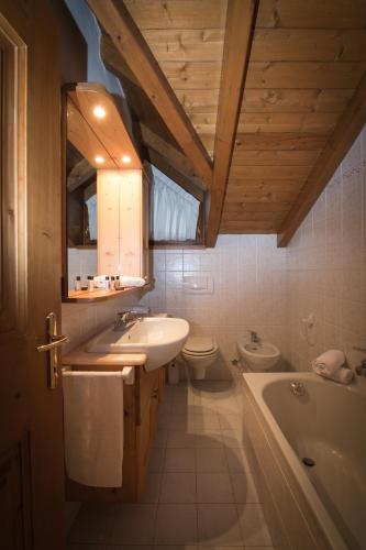 a bathroom with a sink and a toilet and a tub at Casa Le Rondini in Valdisotto
