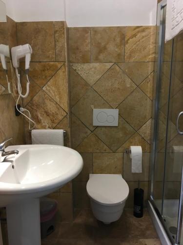 a bathroom with a toilet and a sink at Rainbow Sweet Rooms in Valmontone