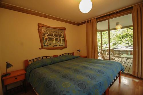 a bedroom with a bed and a view of a patio at Cabañas Nogalia in San Alfonso