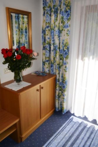a vase of flowers on a dresser in a room at Frühstückspension Christina in Tux