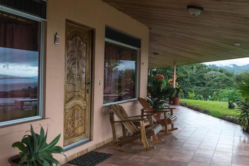 a porch with chairs and a door with a view at Hotel Nepenthe B&B in El Castillo de La Fortuna