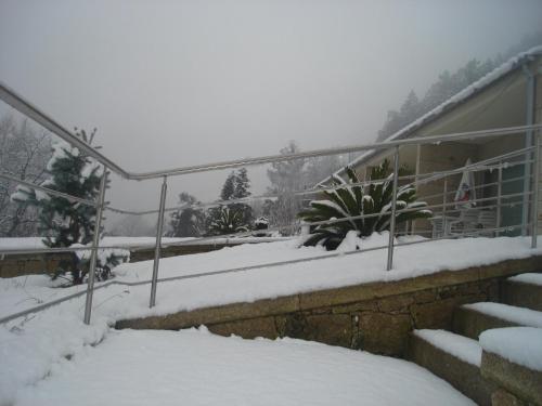 a snow covered balcony of a house with snow on the ground at Casinhas do Gerês in Geres