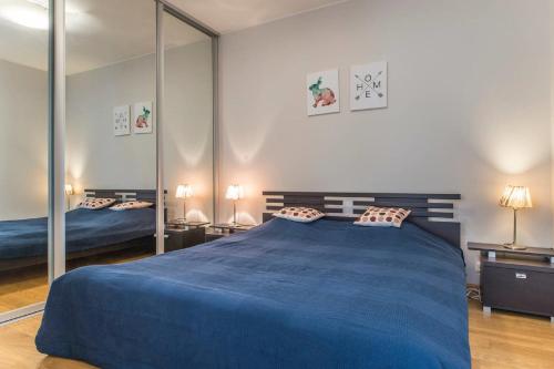 um quarto com uma grande cama azul e espelhos em Old Riga Park Studio em Riga