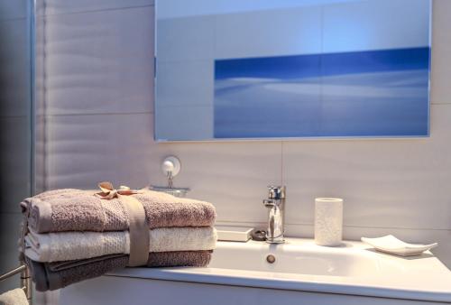 y baño con lavabo y toallas. en La Casa de Sardina en Sardina