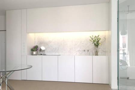 a white kitchen with white cabinets and a table at New Loft - Lisboa Estrela in Lisbon