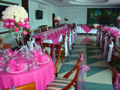 a room with pink tables and chairs with pink napkins at Hotel La Cascada - Lago Agrio in Nueva Loja