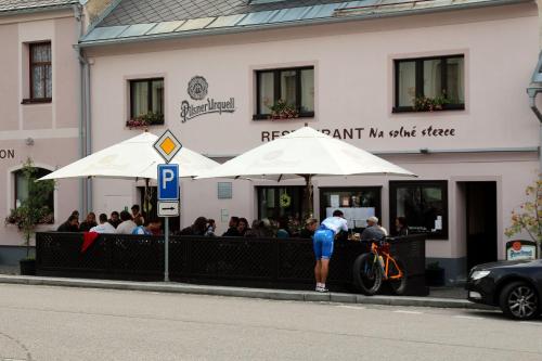 a group of people sitting at a restaurant under umbrellas at Penzion Na Solné stezce in Kašperské Hory