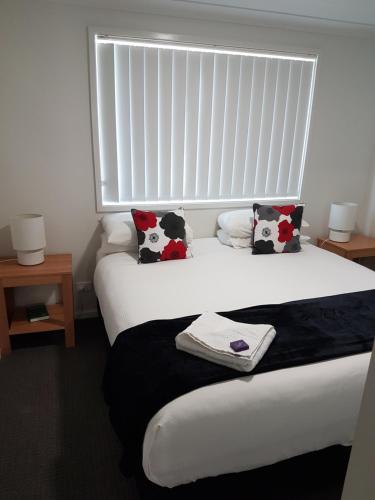 a bed with a white comforter and two pillows at Wallsend Executive Apartments in Newcastle