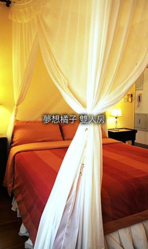 a bedroom with a bed with a white curtain at No. 5 House Homestay in Hualien City