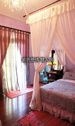 花蓮市的住宿－五號小築民宿 ，一间卧室配有一张带天蓬的床