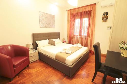 a bedroom with a bed and a chair and a desk at B&B Pietrarsa in Portici