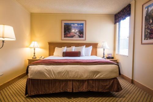 a bedroom with a large bed with two lamps at The Grand Lodge Hotel and Suites in Mount Crested Butte