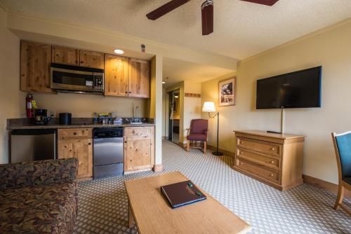 a living room with a kitchen with a couch and a table at The Grand Lodge Hotel and Suites in Mount Crested Butte