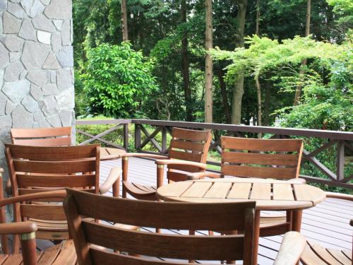 a wooden table and chairs sitting on a deck at Izu Daisenya in Izunokuni