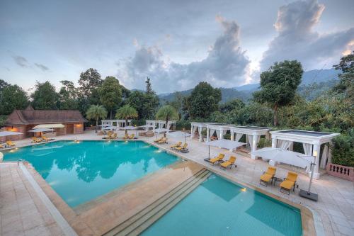 une grande piscine avec des chaises et des parasols dans l'établissement The Chateau Spa & Wellness Resort, à Bukittinggi