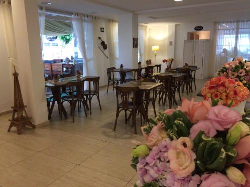 uma sala de jantar com mesas, cadeiras e flores em Scenarium Hotel em Recife