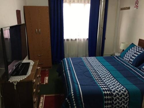 a bedroom with a bed and a dresser and a window at Hospedaje Familiar Glady's House in Puerto Montt