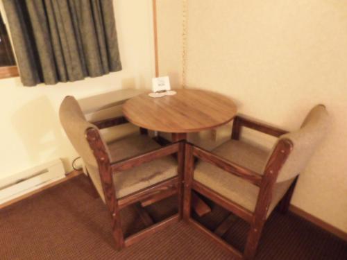 a wooden table and chairs in a room at AmeriVu Inn in Prentice