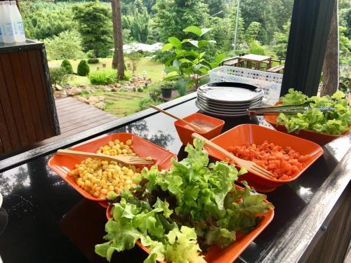 a table with four bowls of vegetables on a balcony at Phu Pha View Doi in Samoeng