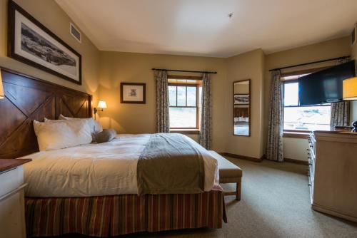 a bedroom with a large bed and a television at The Lodge at Mountaineer Square in Mount Crested Butte