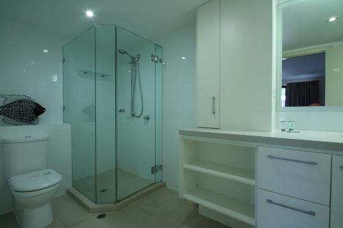 un bagno con doccia in vetro e WC di La Mer Holiday Apartments a Mooloolaba