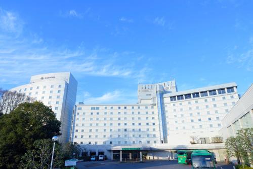 un grand bâtiment blanc avec un parking en face de celui-ci dans l'établissement Narita Tobu Hotel Airport, à Narita