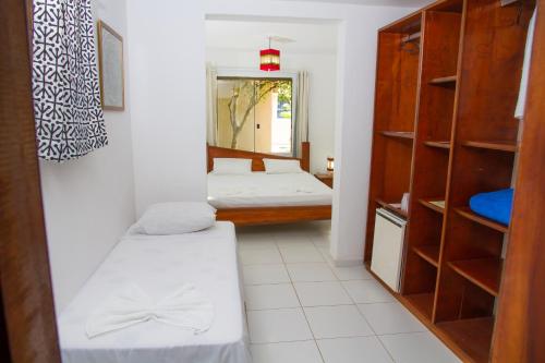 a room with two beds and a mirror at Alto do Aeroporto Hotel in Porto Seguro