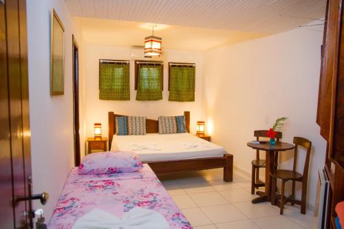 a small bedroom with a bed and a table at Alto do Aeroporto Hotel in Porto Seguro
