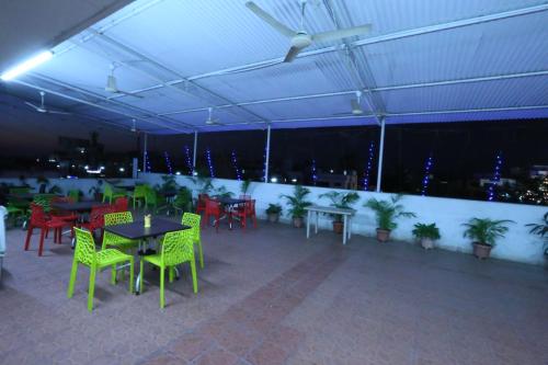 a covered patio with tables and chairs and lights at Hotel Girnar in Aurangabad